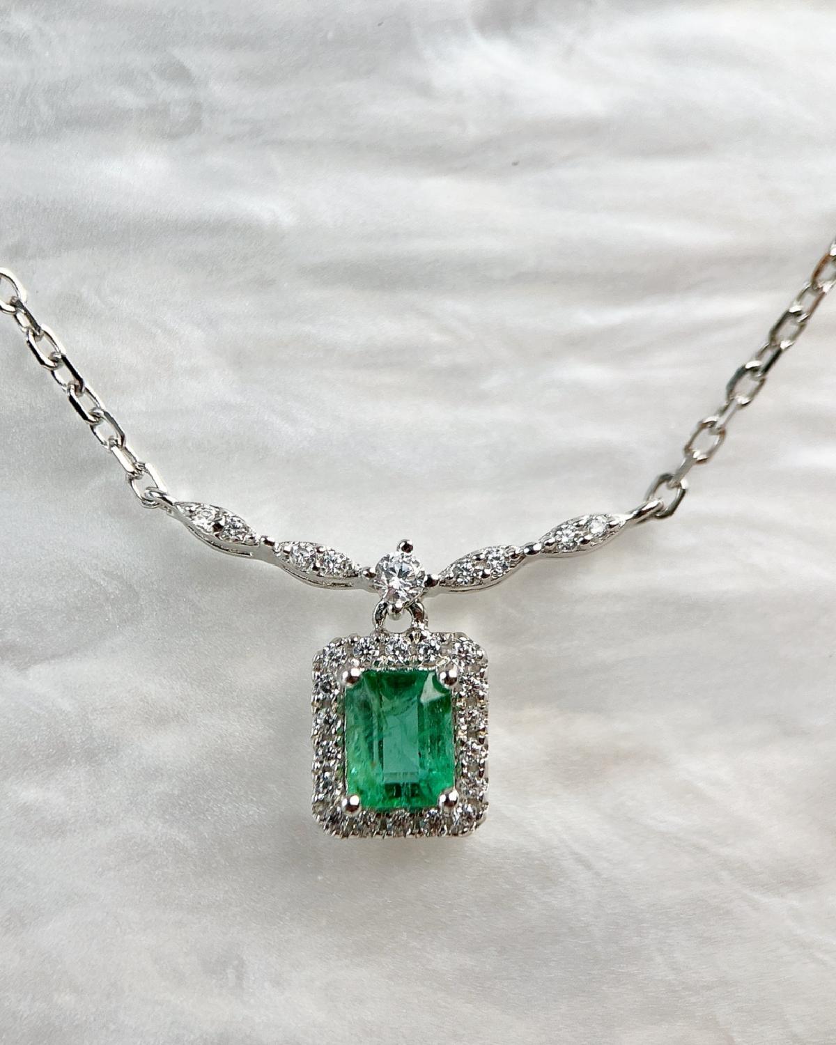 Lifestyle photography of Emerald cut emerald halo necklace featuring Emerald Cut center stone