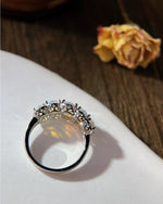 Lifestyle photography of Oval cut opal halo ring featuring Oval Cut center stone