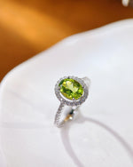 Lifestyle photography of Oval cut peridot halo ring featuring Oval Cut center stone