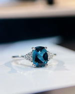 Lifestyle photography of Oval London Blue Topaz Cluster Ring featuring Oval Cut center stone