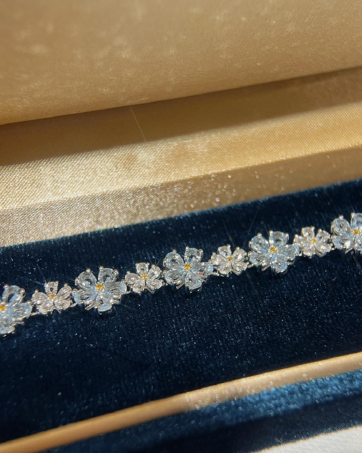 Lifestyle photography of Pear cut aquamarine flower bracelet featuring Pear Cut center stone