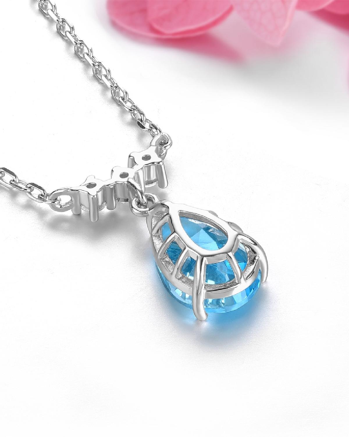 Lifestyle photography of Pear cut blue topaz drop necklace featuring Pear Cut center stone