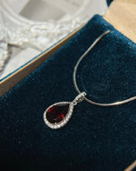Lifestyle photography of Pear cut garnet halo necklace featuring Pear Cut center stone
