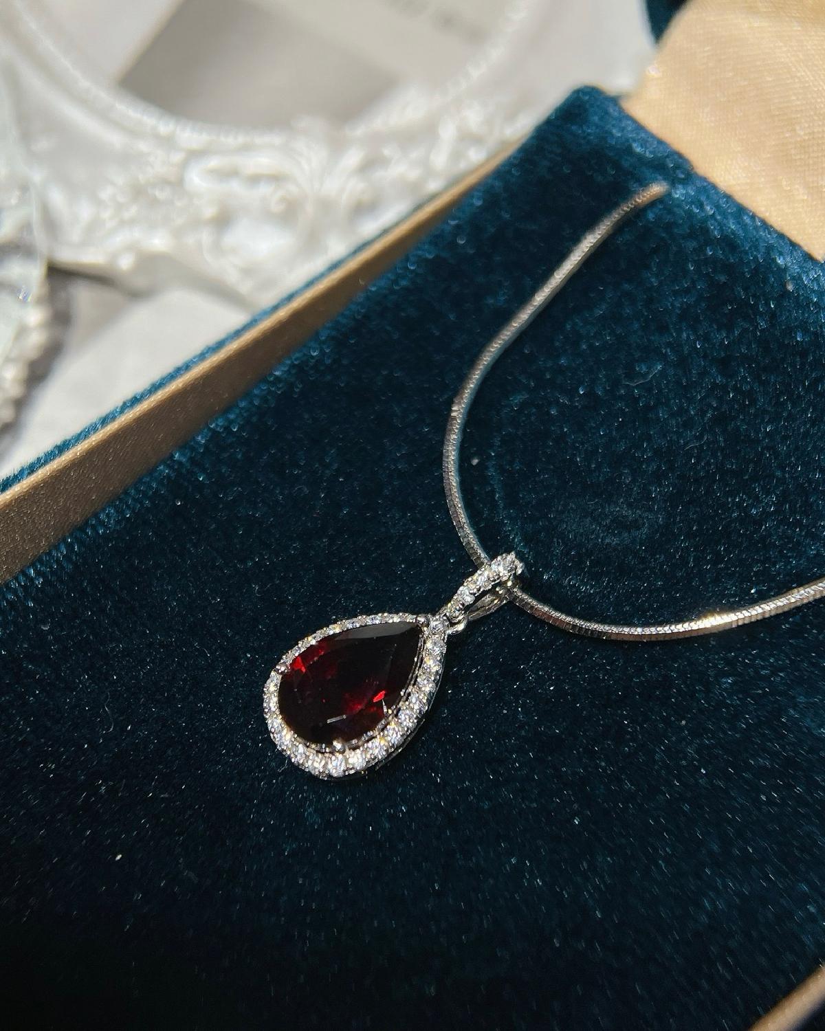 Lifestyle photography of Pear cut garnet halo necklace featuring Pear Cut center stone
