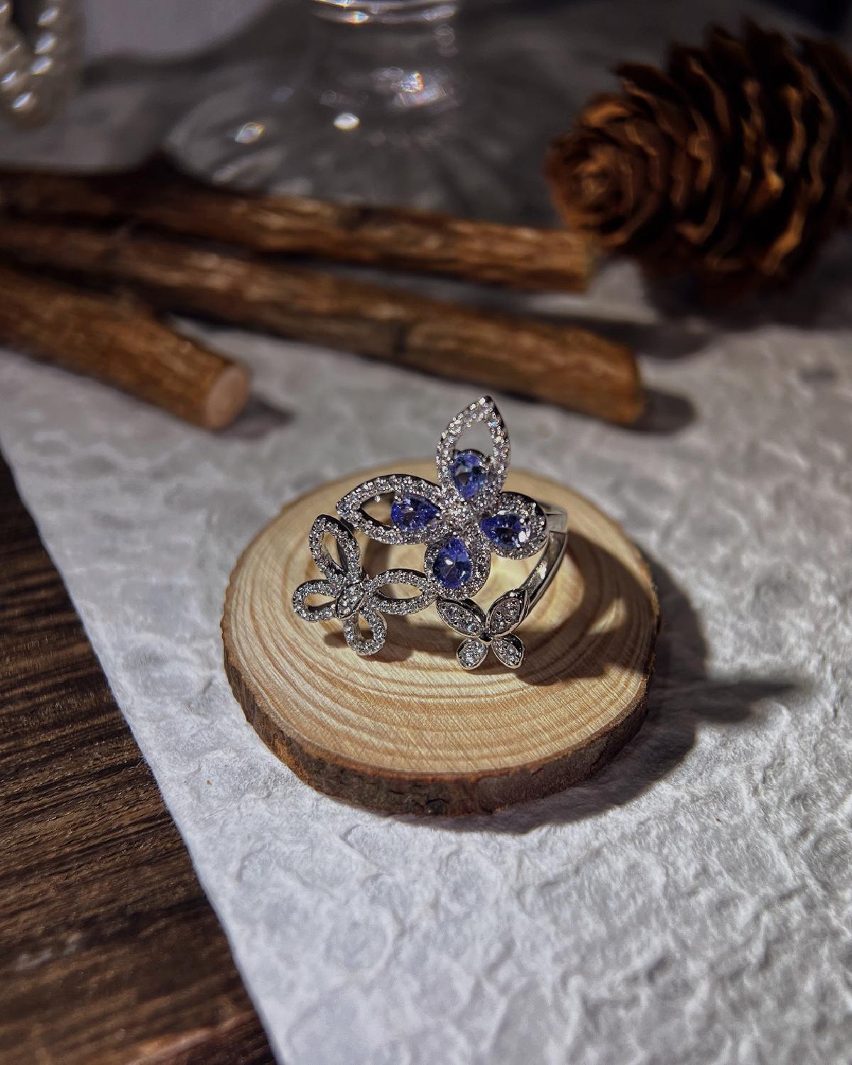 Lifestyle photography of Pear cut tanzanite butterfly cluster ring featuring Pear Cut center stone